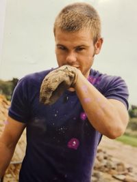 Midsection of man holding ice cream standing outdoors