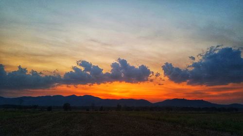 Scenic view of silhouette field against sky during sunset