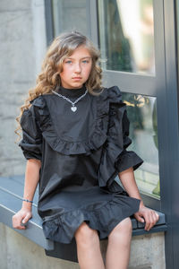 Portrait of woman sitting against window