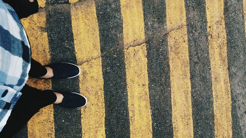 Low section of woman standing on road