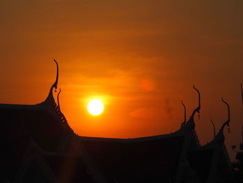 Low angle view of silhouette plants against orange sky