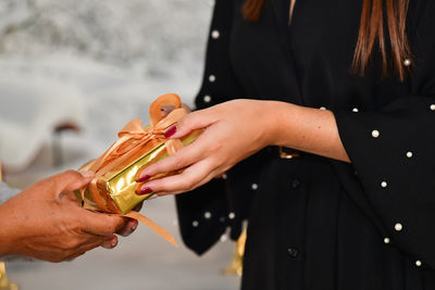 Midsection of woman holding gift outdoors