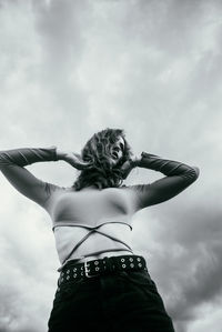 Low angle view of woman standing against sky