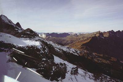 Scenic view of swiss alps against sky seen through titlis in winter