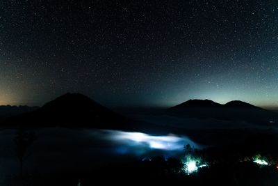 Scenic view of illuminated mountains against sky at night