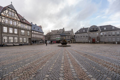 Buildings in city against cloudy sky