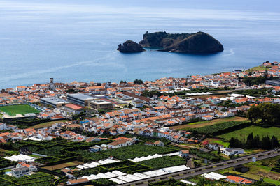 High angle view of townscape by sea against sky