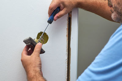 Close-up of man working against wall