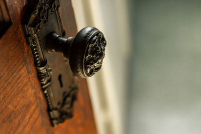 Close-up of ornate doorknob on wooden door