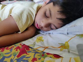 Close-up of baby sleeping on bed at home