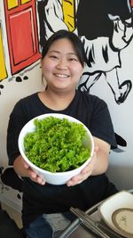 Portrait of a smiling young woman holding food