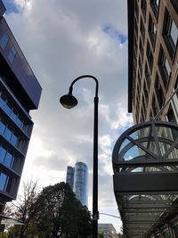 Low angle view of skyscrapers against cloudy sky