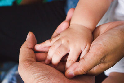 Close-up of mother holding baby hand