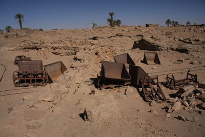 Railway carts on sand at desert sand against sky