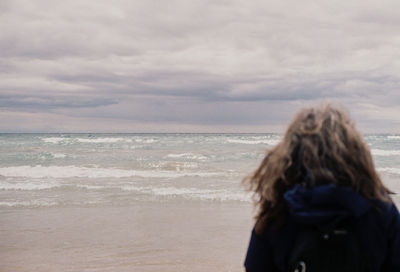 Rear view of woman looking at sea against sky