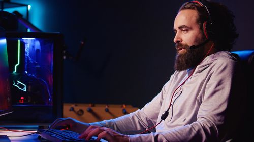 Side view of young man using laptop at home