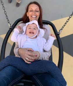 Portrait of happy mother and daughter sitting outdoors