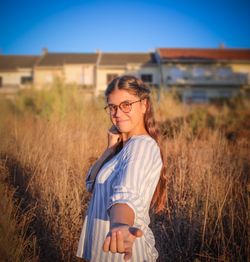 Beautiful woman standing on field against sky
