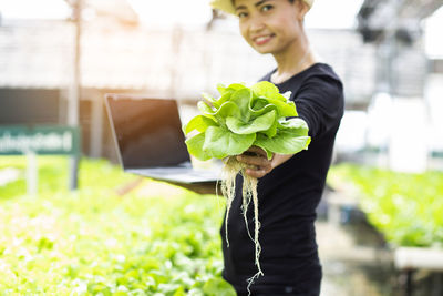 Portrait of boy holding plant