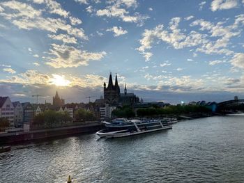 View of mosque at waterfront against cloudy sky