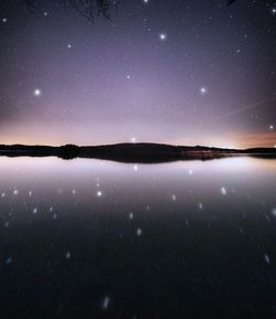 Scenic view of lake against sky at night