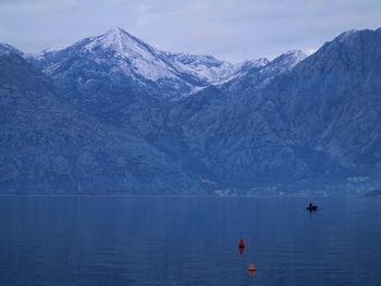 Scenic view of lake and snowcapped mountains against sky