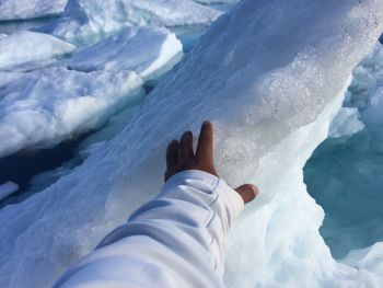 Cropped hand touching ice