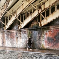 Man walking on bridge in city