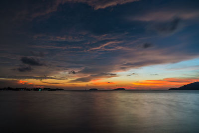 Scenic view of sea against dramatic sky during sunset