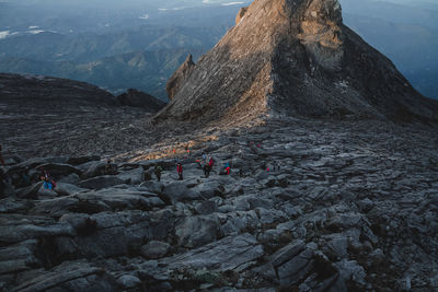 Group of people on rock against mountain range