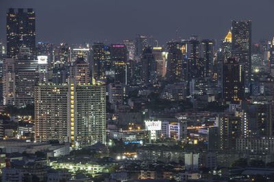 Illuminated cityscape against sky at night