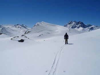 Person skiing on snowcapped mountain against sky