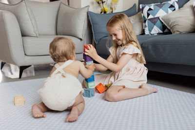 Siblings playing with blocks at home