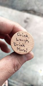 Close-up of person holding hand wine cork with message