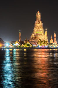 Illuminated temple against sky at night