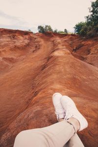 Low section of man sitting on land