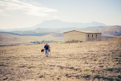 Rear view of man on landscape against sky