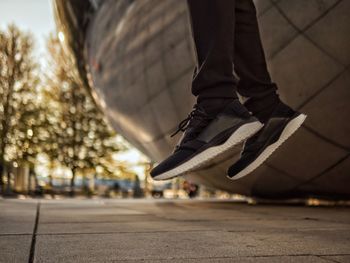 Low section of man jumping by built structure over street