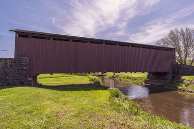 Built structure by river against sky