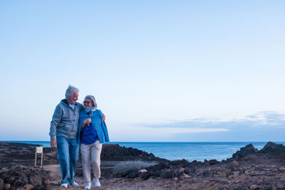 People on sea shore against sky