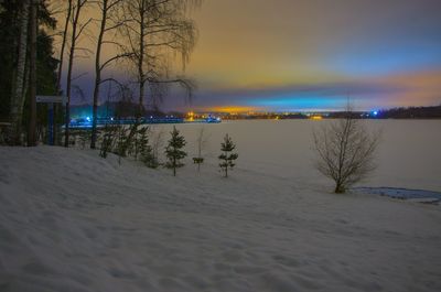 Scenic view of snow covered land against sky at night