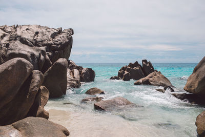 Scenic view of rocks in sea against sky