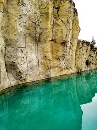 Reflection of rock on wall by swimming pool