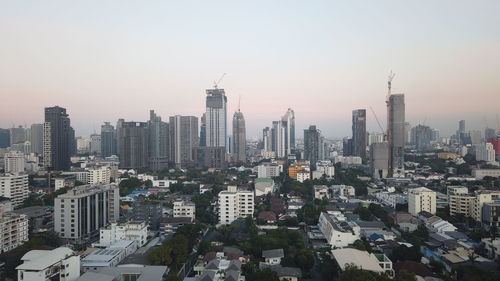Aerial view of buildings in city against sky