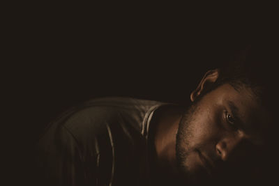 Portrait of man against black background