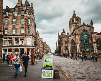 People at cathedral against sky in city