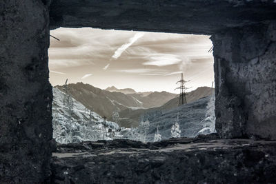 Abandoned building by mountains against sky