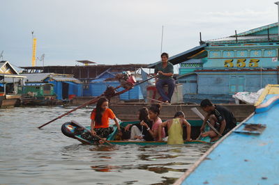 People fishing in river against sky