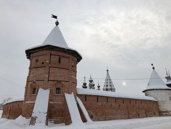 Low angle view of traditional building against sky during winter