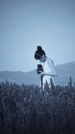 Woman standing on field against sky